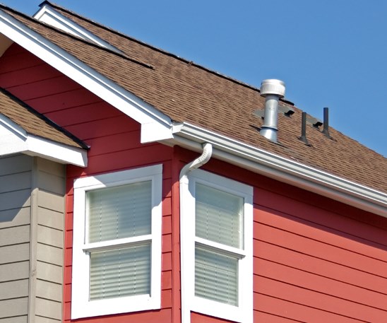 White aluminum gutters installed on a red home.