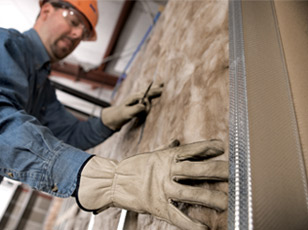 Technician installing fiberglass batt insulation
