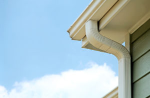Aluminum gutter installation at the corner of a home's roof.